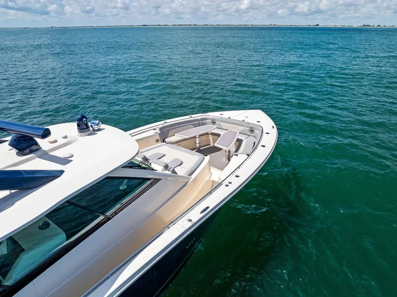Slide: The Image of 2022 Scout LXF boat on clear blue water, showcasing sleek design and spacious deck. - 17