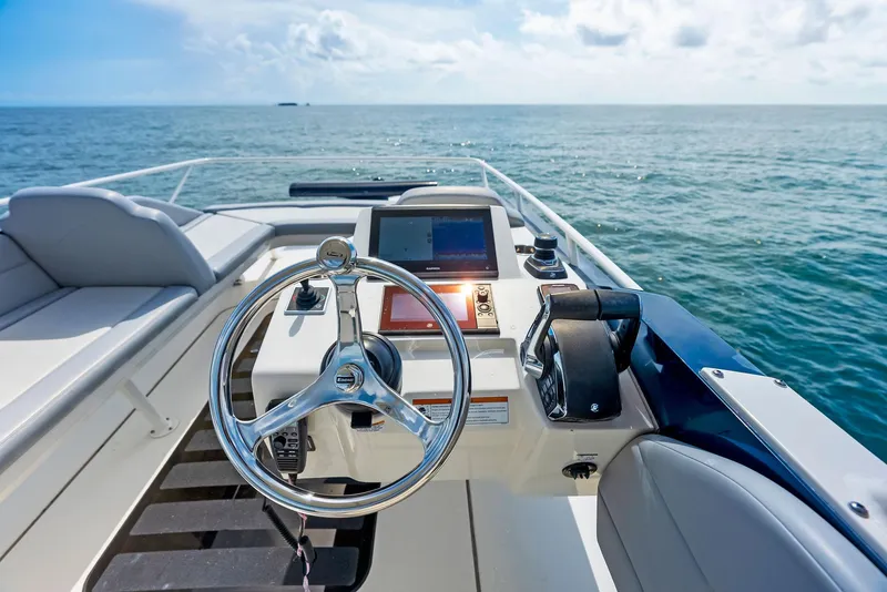 Slide: The Image of 2022 Scout LXF boat helm with ocean view, featuring modern controls and steering wheel. - 33