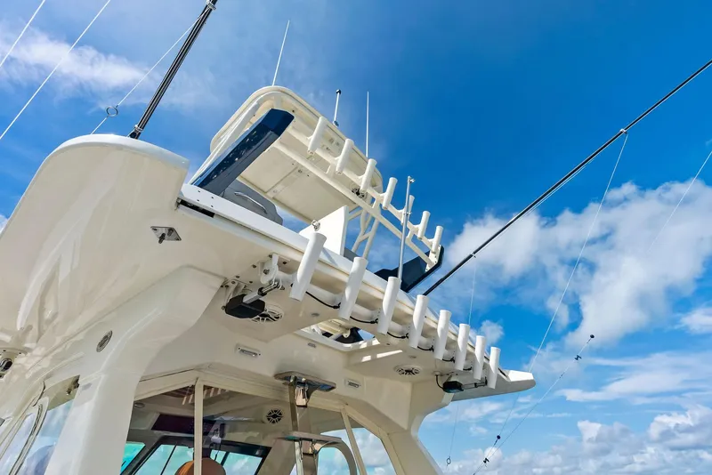 Slide: The Image of 2022 Scout LXF boat with fishing rod holders against a clear blue sky. - 44