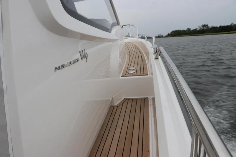Slide: The Image of 2024 Nimbus Weekender 9 boat with sleek design and wooden deck on water. - 1