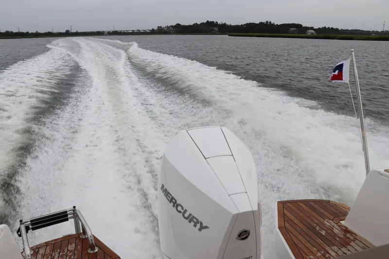 Slide: The Image of Nimbus Weekender 9 boat cruising, leaving a wake on the water, 2024 model. - 14