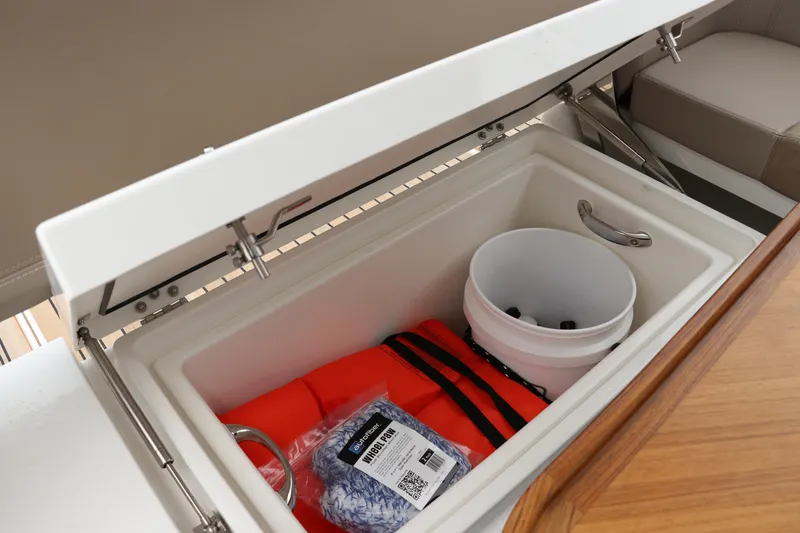 Slide: The Image of Storage compartment in 2024 Nimbus Weekender 9 boat with life jacket and bucket. - 24