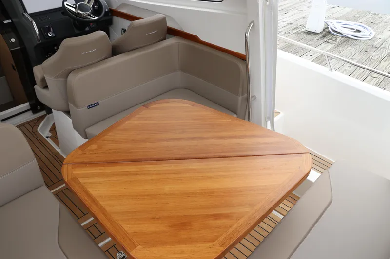 Slide: The Image of 2024 Nimbus Weekender 9 interior with wooden table and beige seating. - 27