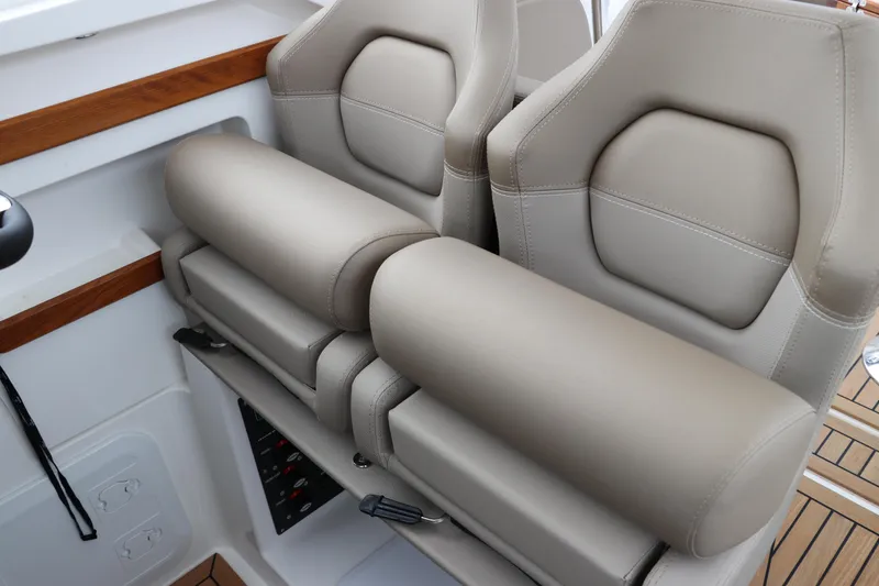 Slide: The Image of 2024 Nimbus Weekender 9 boat interior with beige leather seats and wooden accents. - 43