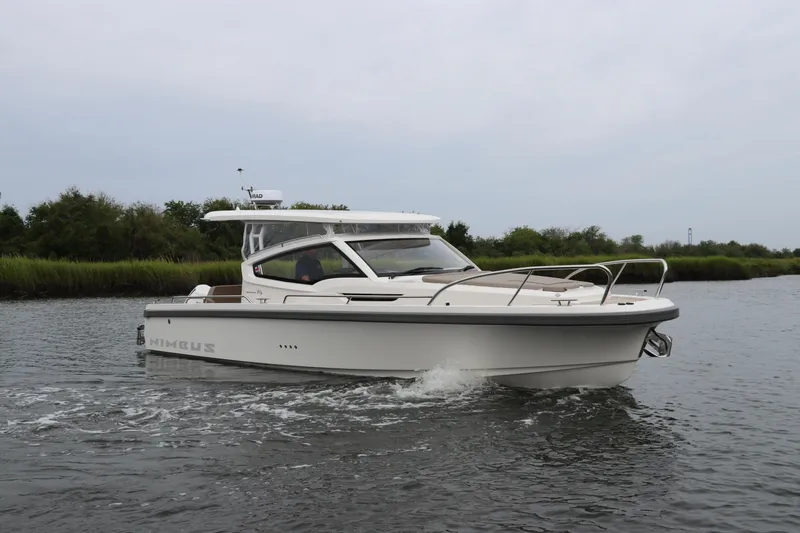 Slide: The Image of 2024 Nimbus Weekender 9 boat cruising on a calm river. - 7