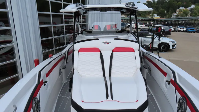 Slide: The Image of 2025 Sunsation 32 CCX boat with sleek white and red seating, docked near a marina. - 18