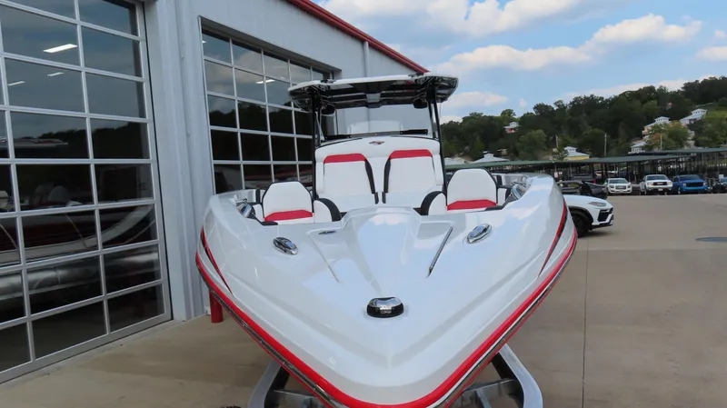 Slide: The Image of 2025 Sunsation 32 CCX boat with sleek design, parked outside a garage. - 2