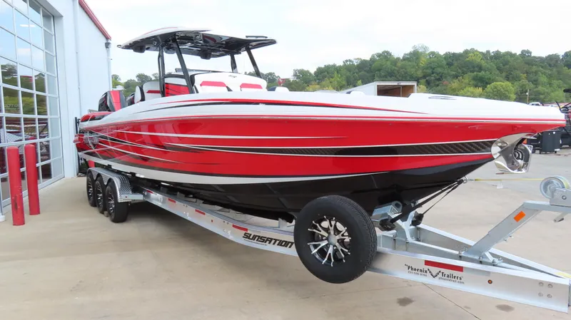 Slide: The Image of 2025 Sunsation 32 CCX boat in vibrant red on a trailer, parked outdoors. - 3