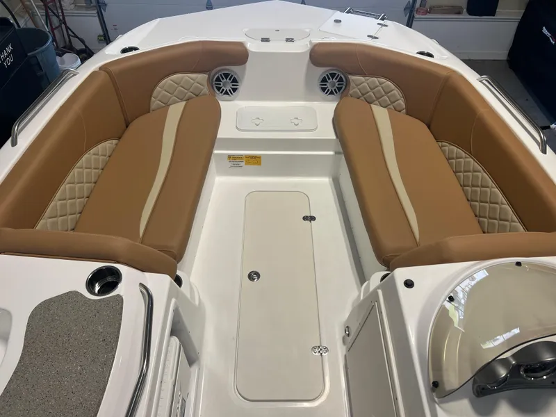 Slide: The Image of 2025 NauticStar 203 SC Deck boat interior with tan seating and storage compartments. - 2