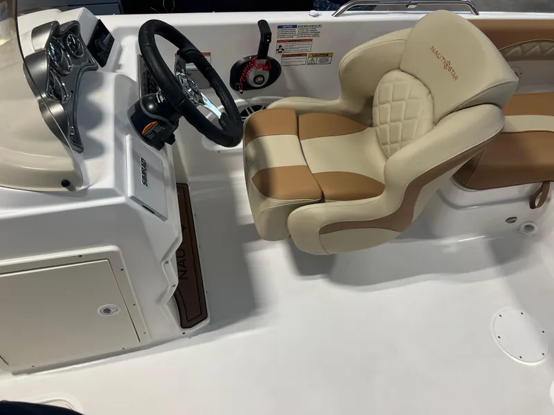 Slide: The Image of 2025 NauticStar 203 SC Deck boat interior with steering wheel and cushioned seating. - 5