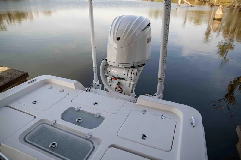 Slide: The Image of 2024 Contender 26 Bay boat with outboard motor on calm water. - 11