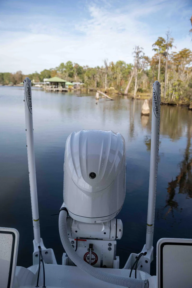 Slide: The Image of 2024 Contender 26 Bay boat on calm lake with trees in background. - 14