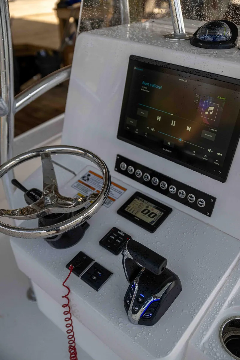 Slide: The Image of 2024 Contender 26 Bay boat dashboard with steering wheel and digital controls. - 21