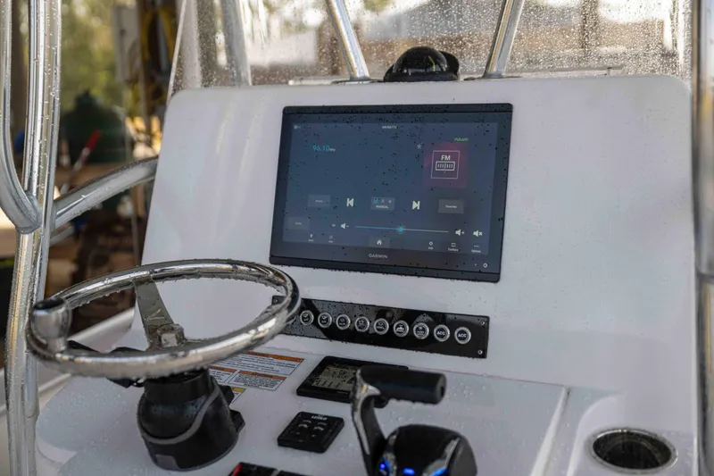 Slide: The Image of 2024 Contender 26 Bay boat dashboard with steering wheel and touchscreen display. - 28