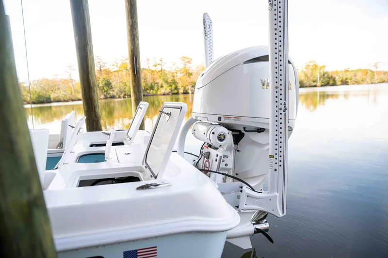 Slide: The Image of 2024 Contender 26 Bay boat with outboard motor docked on calm water. - 30