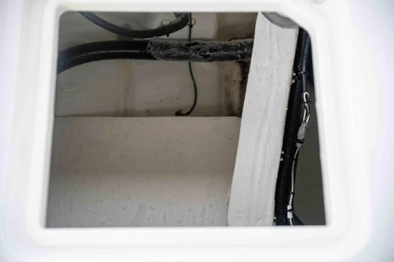 Slide: The Image of 2024 Contender 26 Bay boat interior compartment with wiring and hoses. - 34