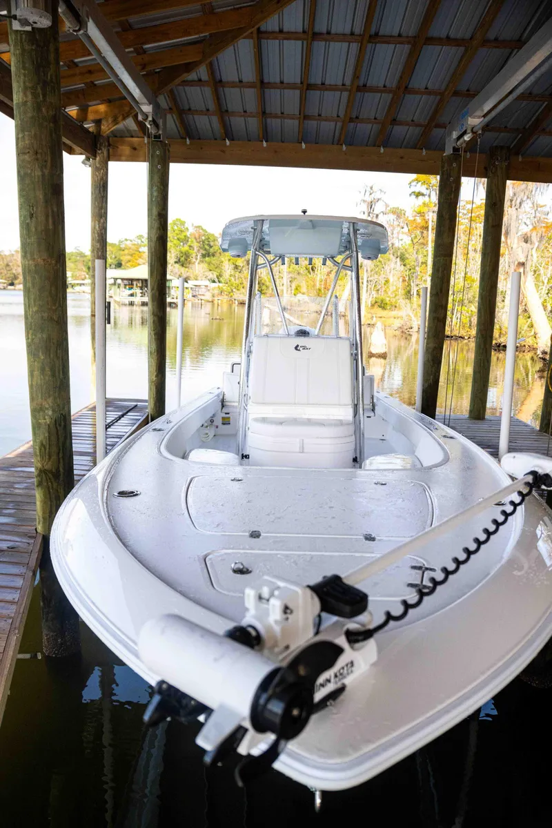 Slide: The Image of 2024 Contender 26 Bay boat docked under a wooden shelter. - 35