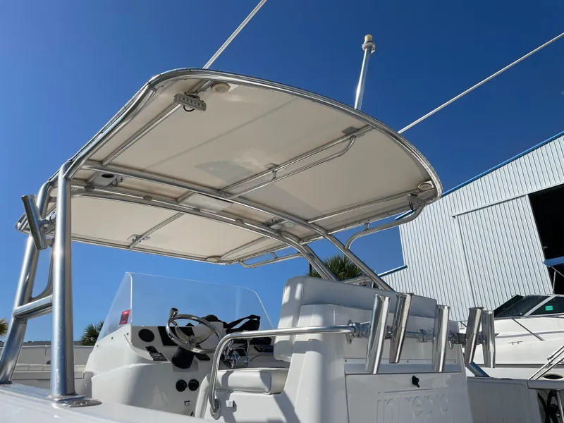 Slide: The Image of 2008 Intrepid 323 Cuddy boat with T-top and helm station, docked near a warehouse. - 14