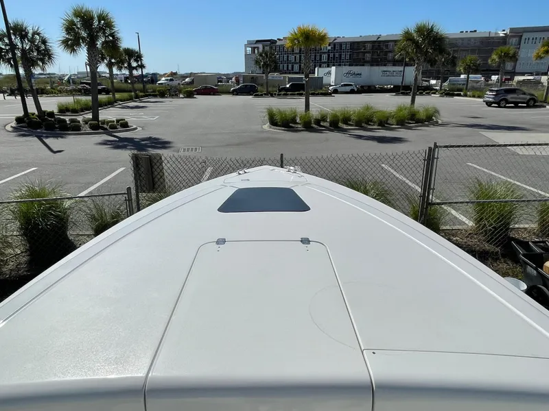 Slide: The Image of 2008 Intrepid 323 Cuddy boat parked near palm trees and buildings. - 18