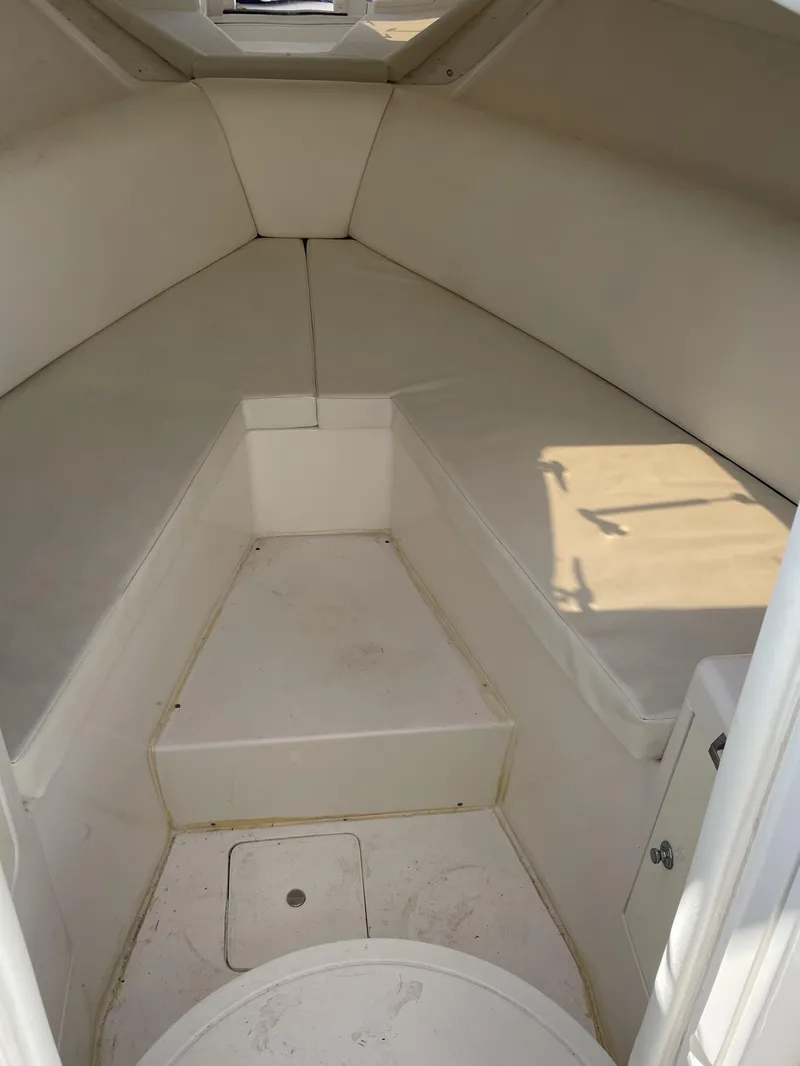 Slide: The Image of Interior of 2008 Intrepid 323 Cuddy cabin, featuring white seating and storage. - 20