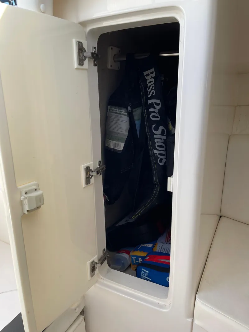 Slide: The Image of Storage compartment on a 2008 Intrepid 323 Cuddy boat with fishing gear inside. - 24