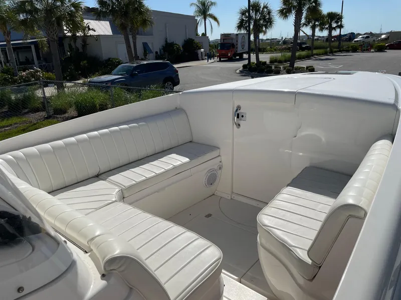 Slide: The Image of 2008 Intrepid 323 Cuddy boat interior with white seating and sunny outdoor setting. - 25