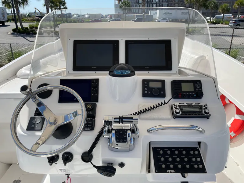Slide: The Image of Control panel of a 2008 Intrepid 323 Cuddy boat with steering wheel and navigation equipment. - 31