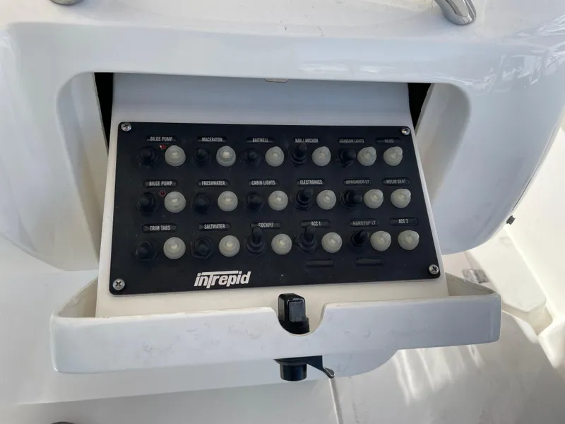 Slide: The Image of Control panel of a 2008 Intrepid 323 Cuddy boat with labeled switches. - 37