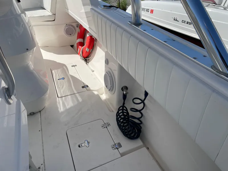 Slide: The Image of 2008 Intrepid 323 Cuddy boat interior with white seating, storage compartments, and safety equipment. - 38