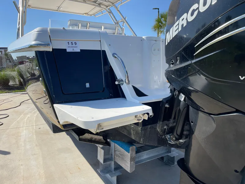 Slide: The Image of 2008 Intrepid 323 Cuddy boat with Mercury outboard engine, docked on a sunny day. - 8