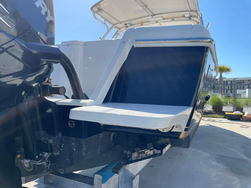 Slide: The Image of 2008 Intrepid 323 Cuddy boat with outboard motor, docked under clear blue sky. - 9