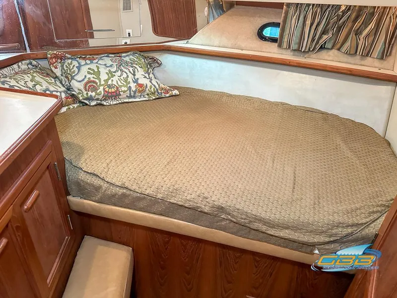 Slide: The Image of 1989 Carver 3807 Aft Cabin bedroom with cozy bed and floral pillows. - 19