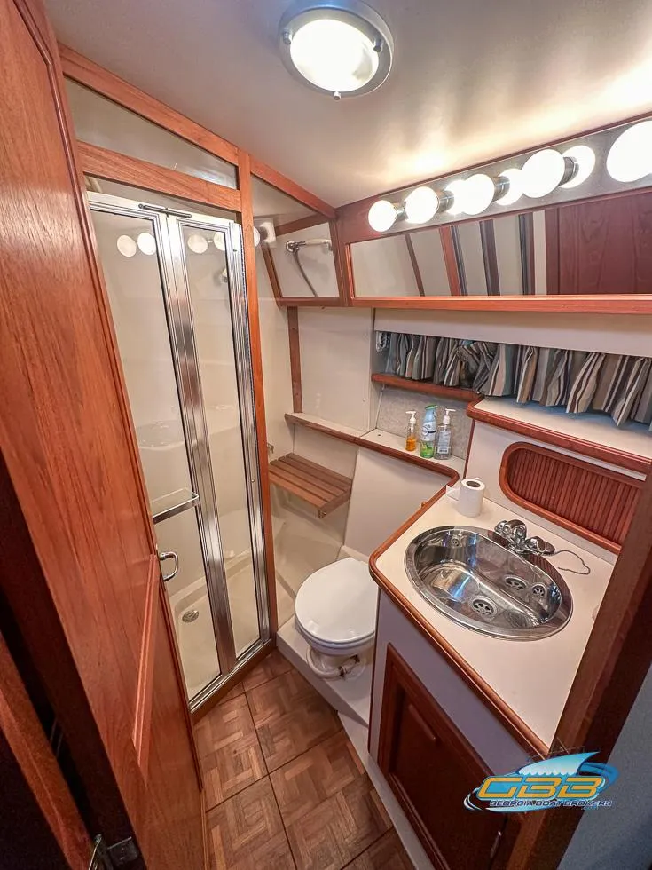 Slide: The Image of 1989 Carver 3807 Aft Cabin bathroom with shower, sink, and wood accents. - 21