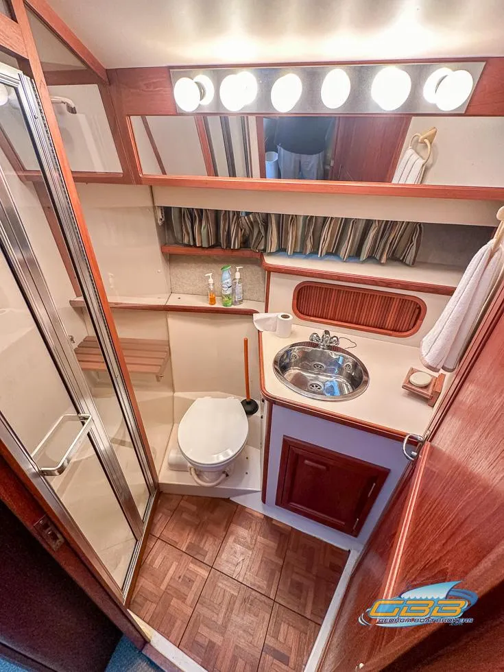 Slide: The Image of 1989 Carver 3807 Aft Cabin bathroom with shower, sink, and wood accents. - 24