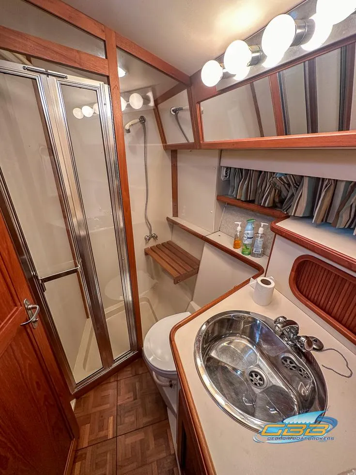 Slide: The Image of 1989 Carver 3807 Aft Cabin bathroom with shower, sink, and wooden accents. - 26