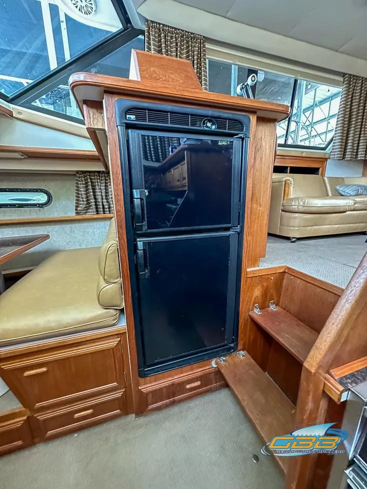 Slide: The Image of 1989 Carver 3807 Aft Cabin interior with wood cabinetry and compact refrigerator. - 29