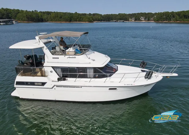 Slide: The Image of 1989 Carver 3807 Aft Cabin yacht cruising on a serene lake. - 4