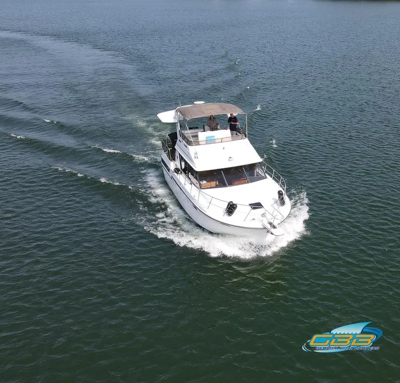 Slide: The Image of 1989 Carver 3807 Aft Cabin cruising on open water, aerial view. - 10