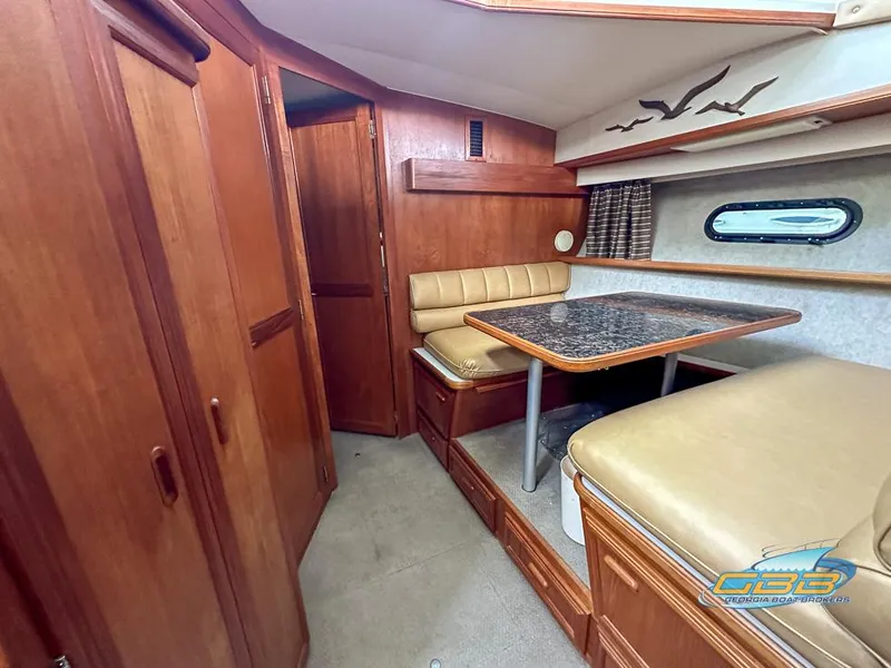 Slide: The Image of 1989 Carver 3807 Aft Cabin interior with dining area, wood finish, and porthole window. - 28