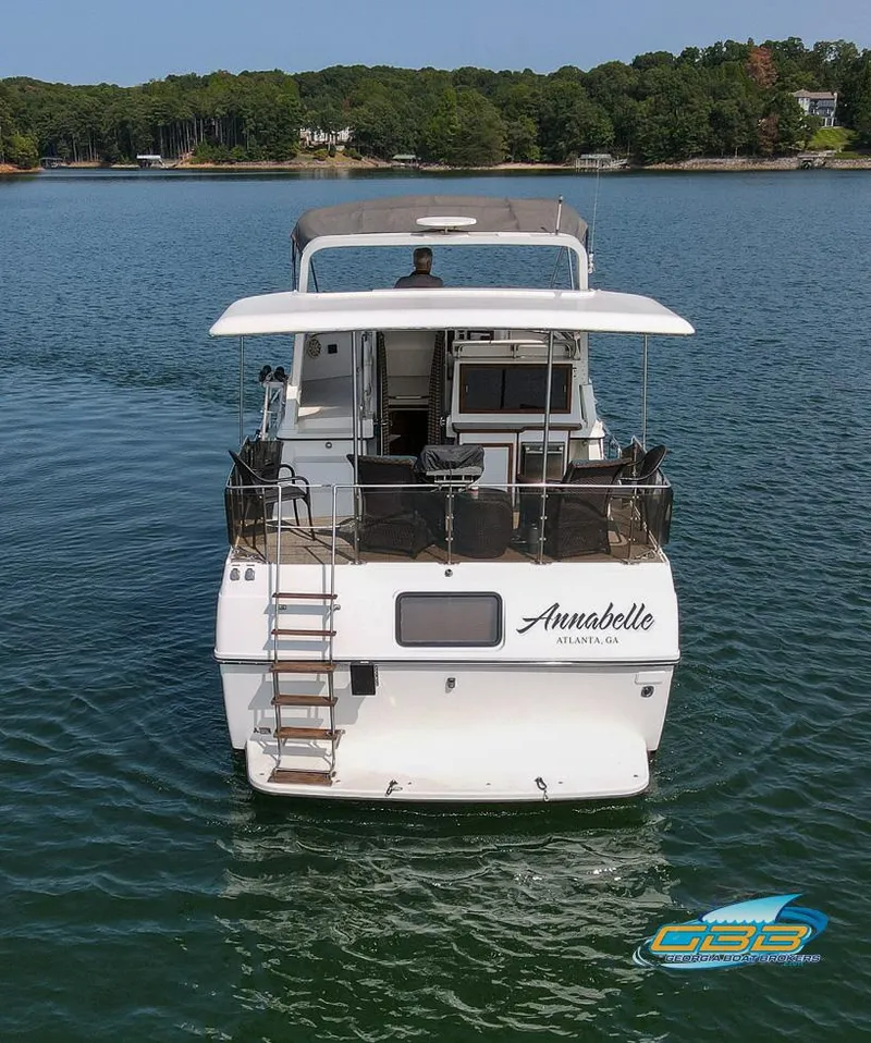 Slide: The Image of 1989 Carver 3807 Aft Cabin yacht on serene lake, rear view. - 3