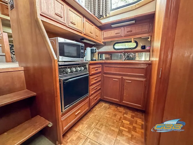 Slide: The Image of 1989 Carver 3807 Aft Cabin kitchen with wood cabinetry and modern appliances. - 32