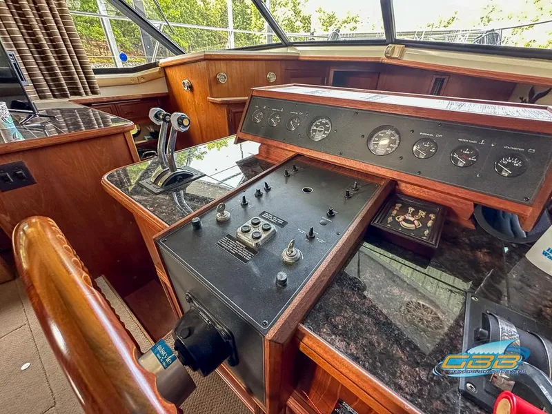 Slide: The Image of 1989 Carver 3807 Aft Cabin helm with control panel and gauges. - 36