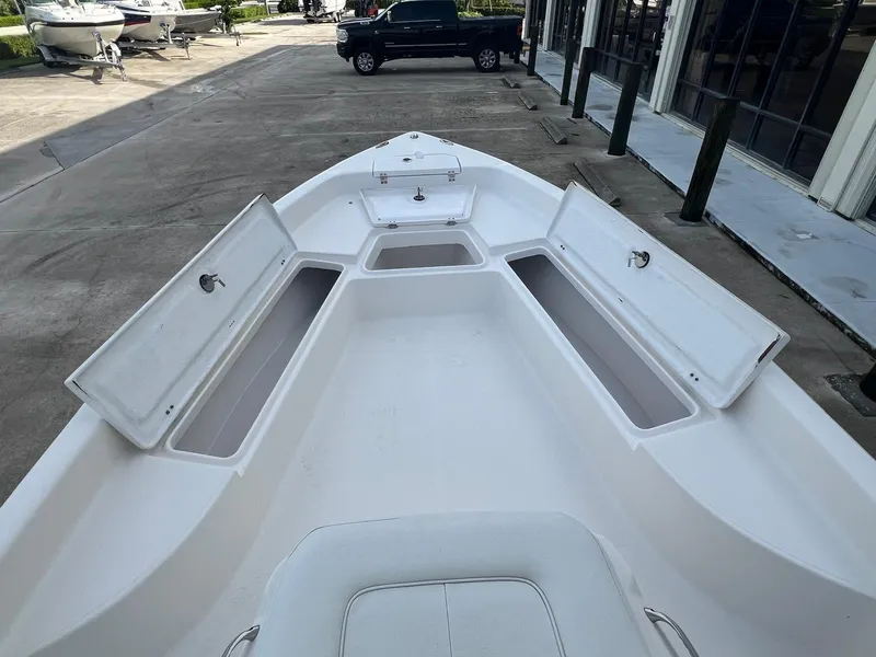 Slide: The Image of 2022 Clearwater 2100 Baystar boat with open storage compartments, docked outdoors. - 13