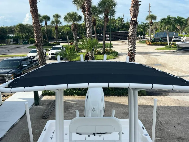 Slide: The Image of 2022 Clearwater 2100 Baystar boat with T-top, parked near palm trees. - 15