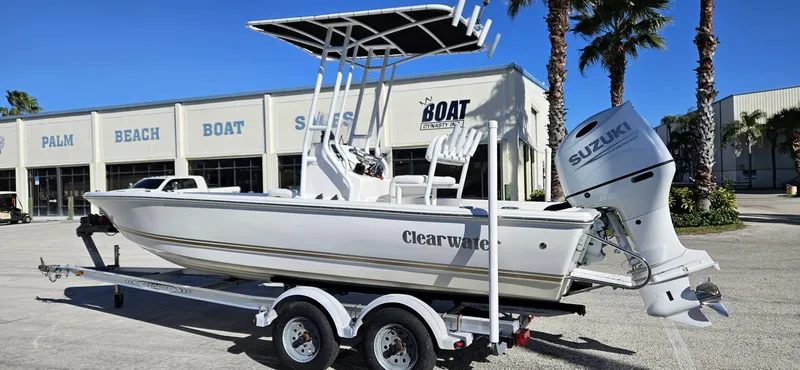Slide: The Image of 2022 Clearwater 2100 Baystar boat with Suzuki engine on trailer, parked outside dealership. - 2