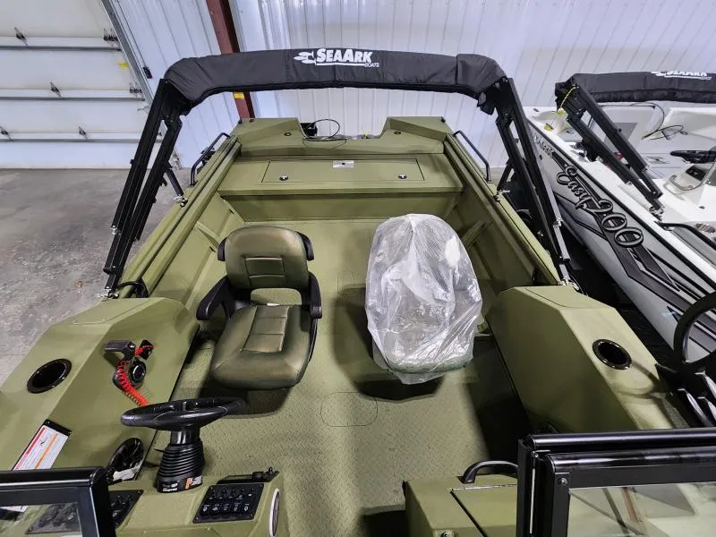 Slide: The Image of 2025 SeaArk Protege boat interior with seating and controls in a showroom. - 2