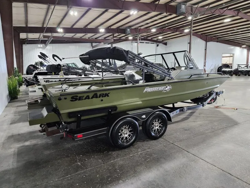 Slide: The Image of 2025 SeaArk Protege boat in showroom, green exterior, on a dual-axle trailer. - 5