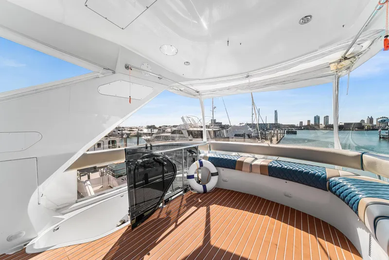 Slide: The Image of Luxurious 2007 Marquis 55 LS yacht deck with seating, overlooking marina and city skyline. - 23