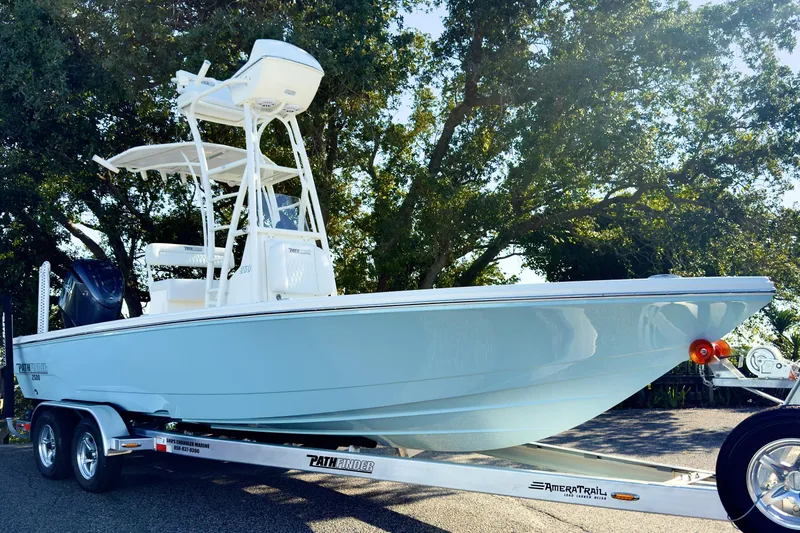 The Image of 2026 Pathfinder 2500 Hybrid boat on trailer, sleek design, light blue color, outdoor setting. - 0