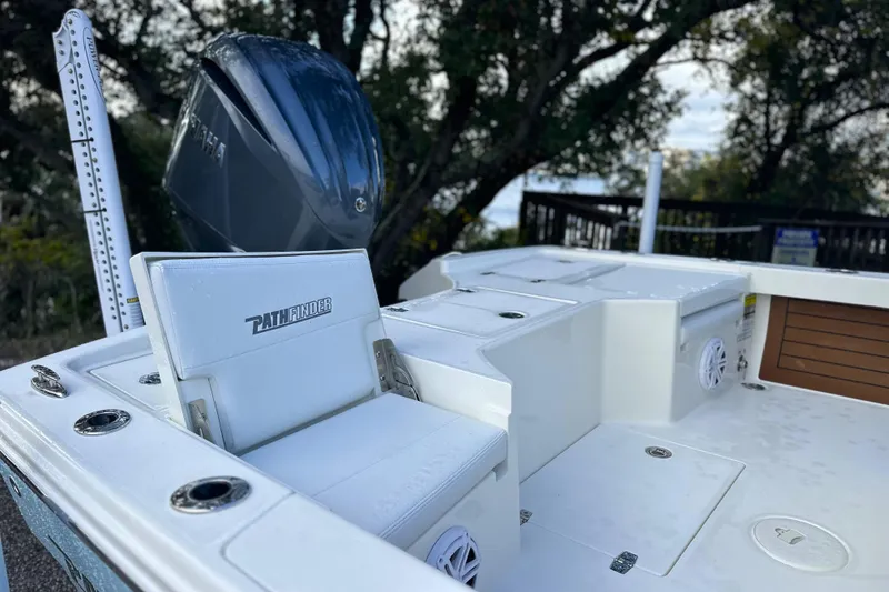 Slide: The Image of 2026 Pathfinder 2500 Hybrid boat interior with seating and motor, surrounded by trees. - 24